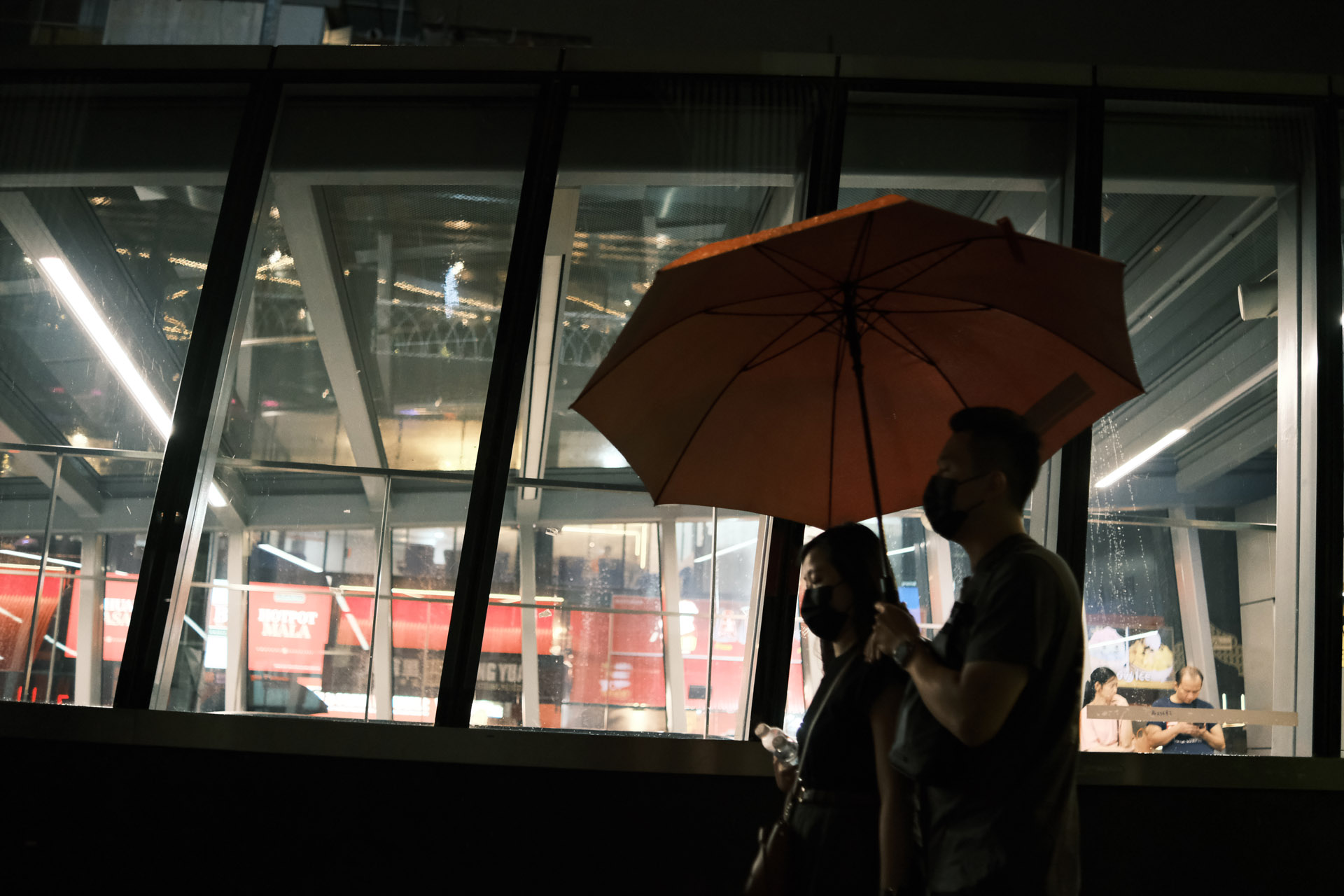 A man holding red umbrella at rainy night - Classic Negative Low Light Film Simulation Recipe