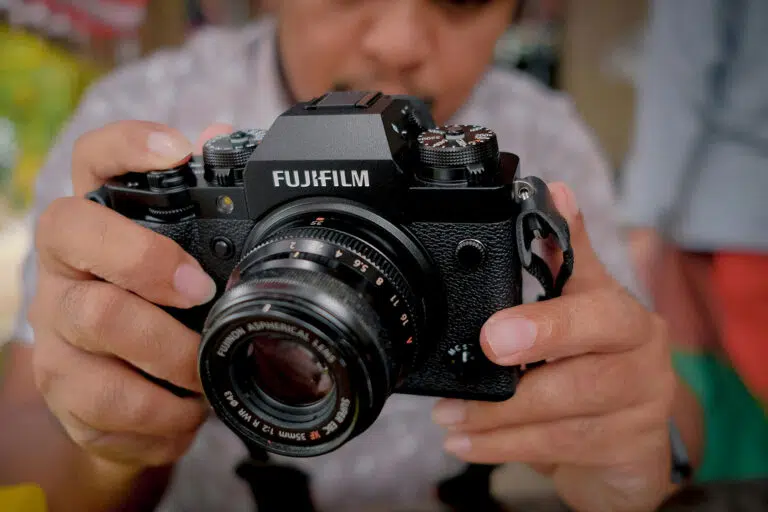 A man holding a Fujifilm X-T2 camera