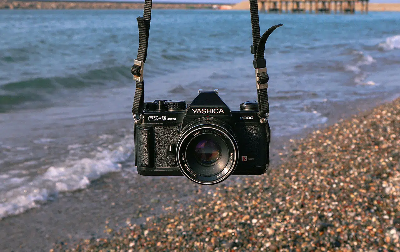 Yashica FX-3 Super 2000 film camera with sea on the background