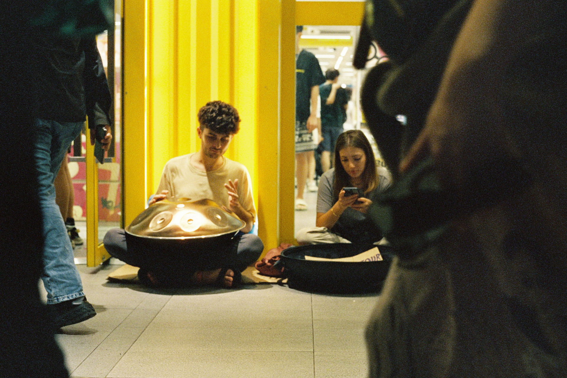 CineStill 800T - Man & woman sitting on the floor playing musical instruments