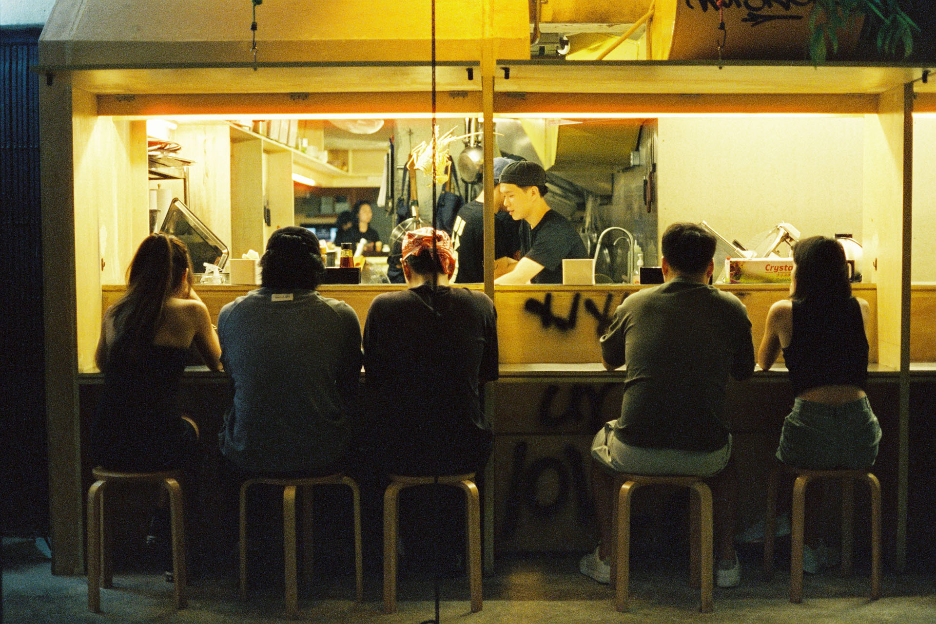 CineStill 800T Scene in Chinatown - Group of people sitting at Japanese Ramen shop in Chinatown Kuala Lumpur